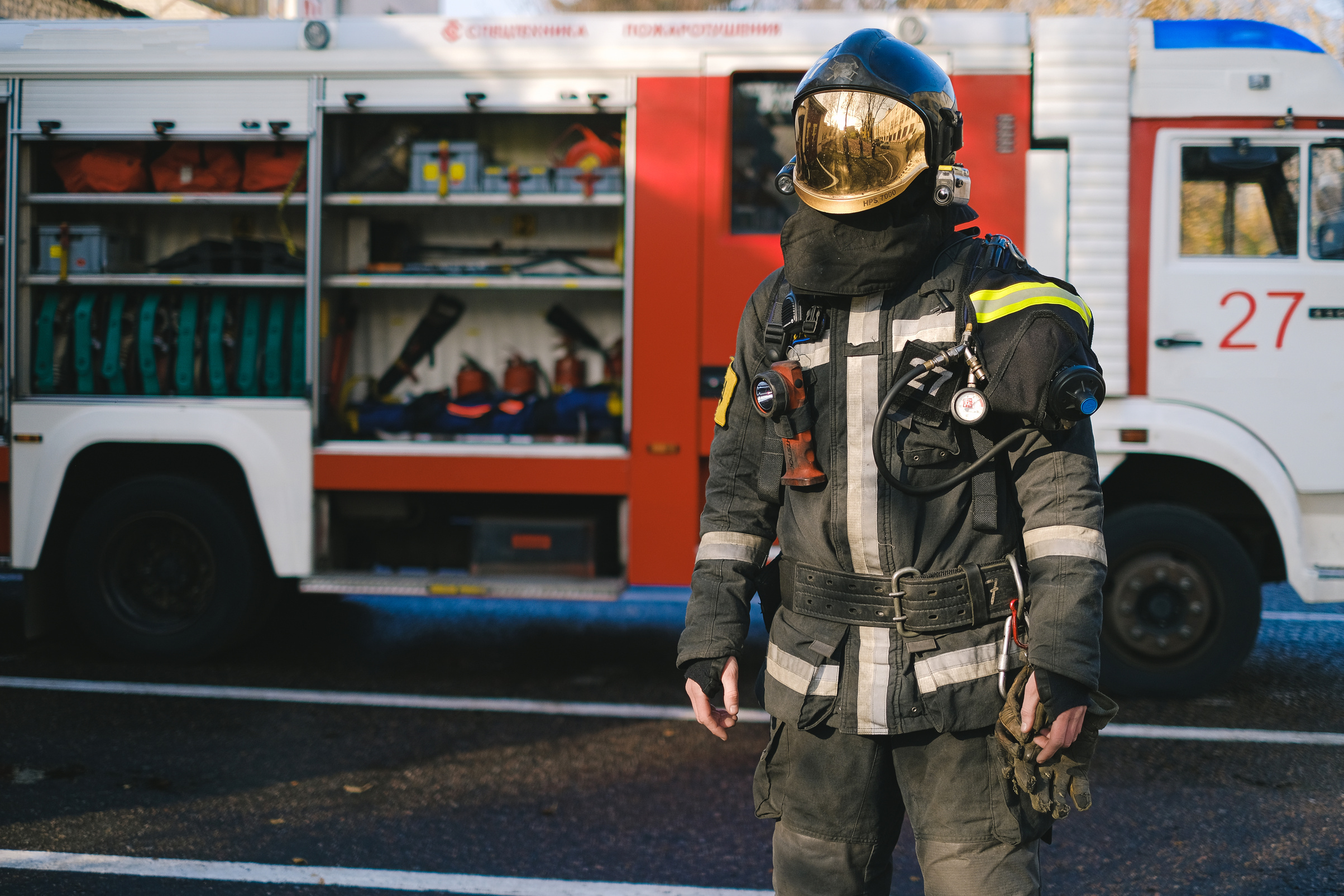 A Firefighter in Uniform Standing Near a Fire Truck